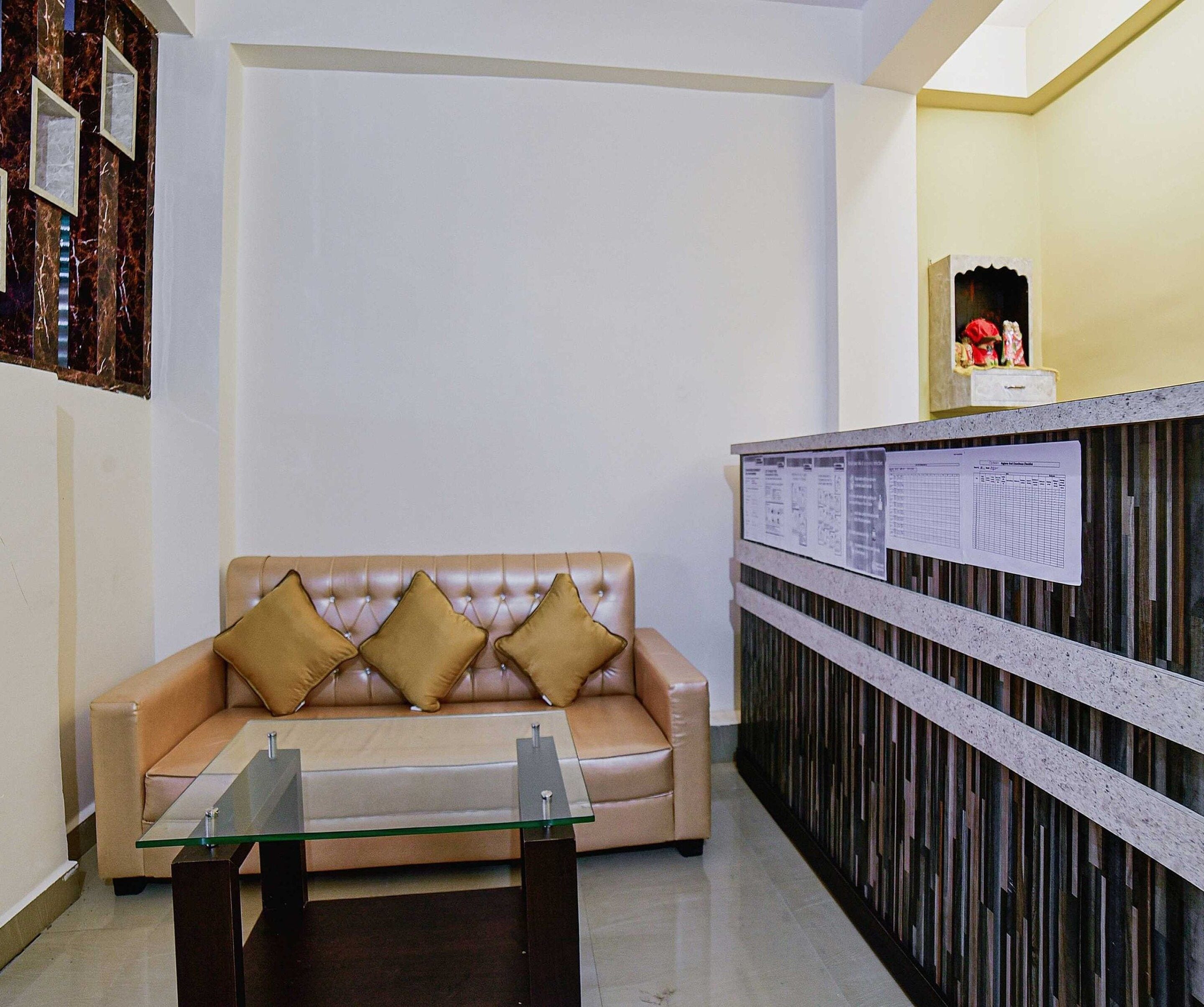A reception area with a leather sofa, a glass-top table, and a bulletin board with papers.