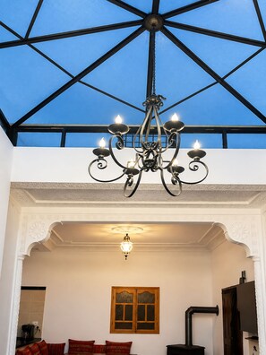 A room with a chandelier, a wooden window, and a stove. - Villa Saidora - Marrakesh (Marrakech)