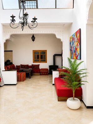 A spacious living area with a fireplace, a large window, and a colorful abstract painting.