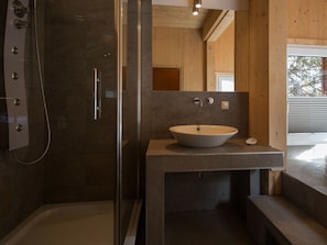 A modern bathroom with a glass-enclosed shower, a freestanding bathtub, and a large sink with a wooden countertop. - Cabin in Turrach With Sauna and Wi-fi (Stadl-Predlitz)