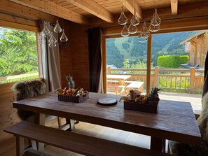 Ein Holzinnenraum mit einem Tisch, der mit Obstkörben und einer Bank bestückt ist.