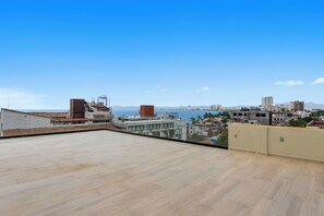 A rooftop terrace with a clear view of the sea and city skyline. - The Malecon Penthouse Studio 1 Block to Beach & Sea (Puerto Vallarta)