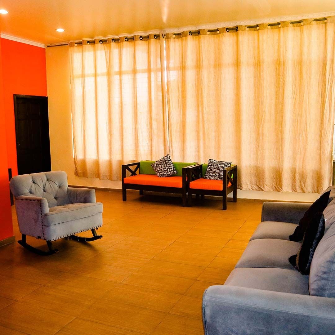 A living room with a sofa, armchair, and a small table with decorative pillows.