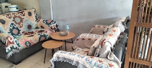 Una habitación con un conjunto de sofá, una mesita redonda y una botella de agua.