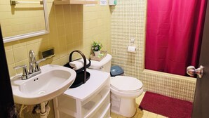 Une salle de bain comprenant un lavabo, des toilettes et un espace douche.