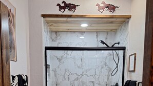 A bathroom with a glass-enclosed shower, a toilet, and a vanity with a marble countertop. - Secluded Sunset a charming rustic 1-bedroom cabin in Ringold (Ringold)