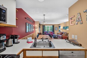 Una cocina moderna equipada con lavavajillas, cafetera y un lavabo.