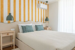 A hotel room with a bed, bedside tables, and a wall-mounted air conditioner. - Wave 2.3 • Design and Conforto junto à Praia com AC (Vila Nova de Gaia)