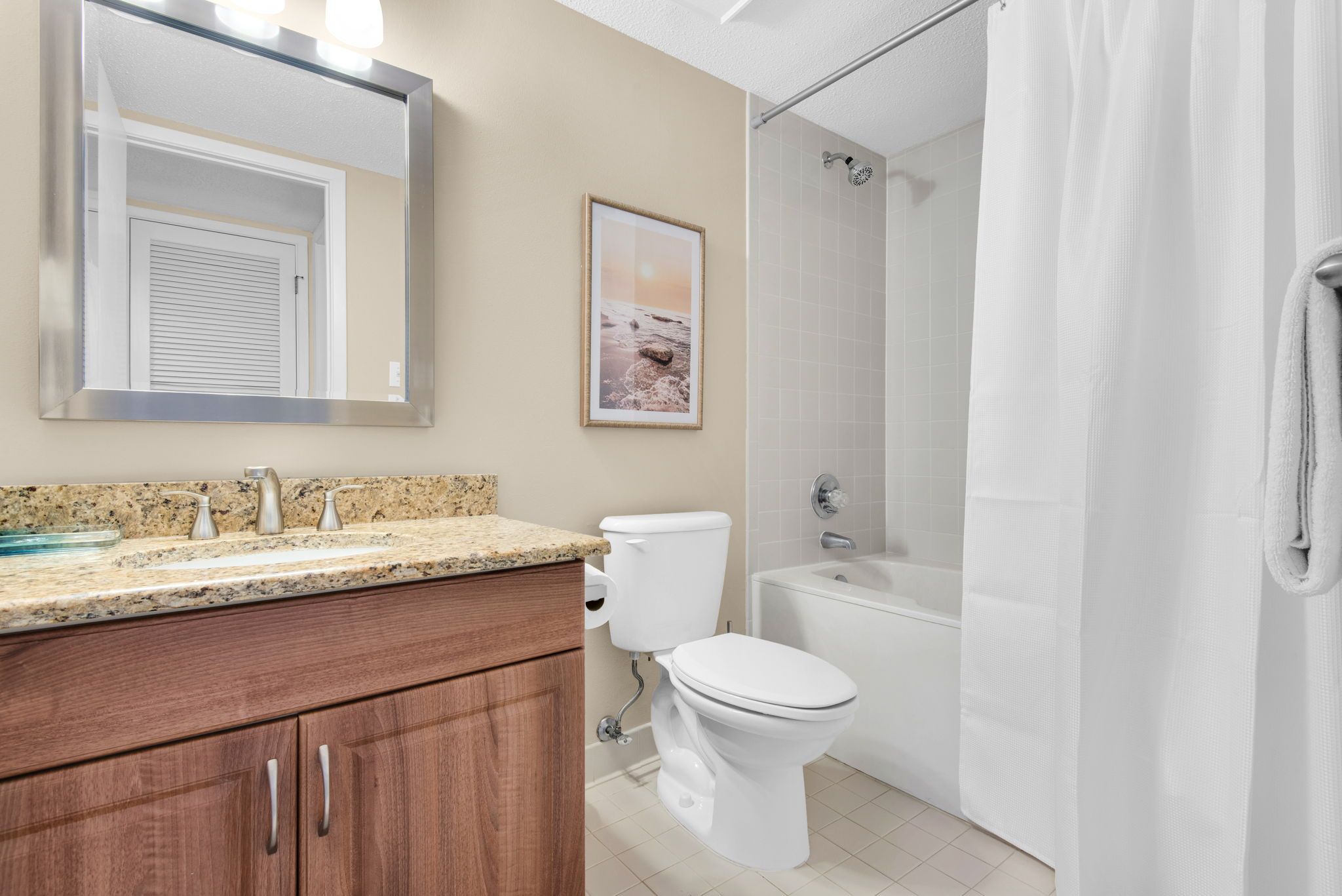 A bathroom with a toilet, sink, and shower area.