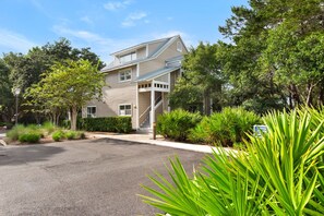 A two-story house with a covered porch and a driveway leading to the entrance. - First Floor Cottage at Hidden Dunes, Near Tennis Courts (Miramar Beach)