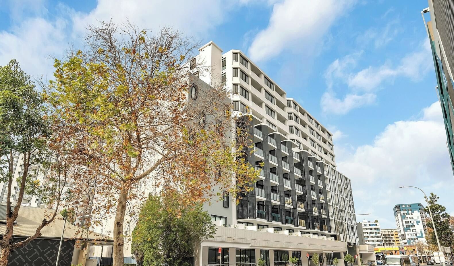 A multi-story building with balconies, a flat facade, and a clear sky.