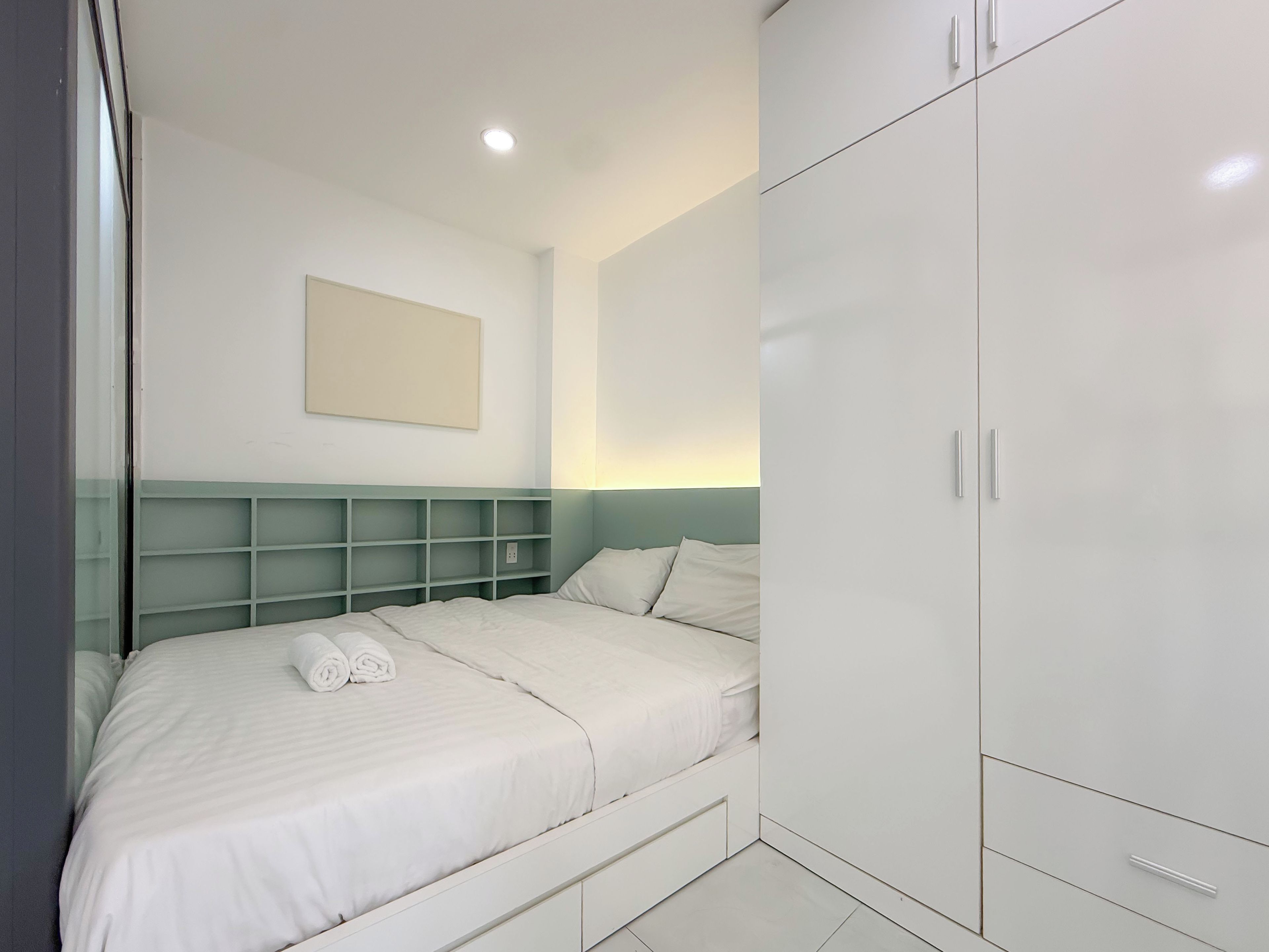 Un dormitorio moderno con una cama, un armario y una estantería.