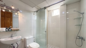 A modern bathroom with a glass-enclosed shower, a white sink, and a toilet. - Quynh Khang Apartments & Hotels (Ho Chi Minh)