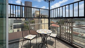A balcony with a table and chairs, a railing, and a view of the cityscape. - Quynh Khang Apartments & Hotels (Ho Chi Minh)