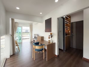 A modern interior with a dining area, a desk, and a wardrobe.