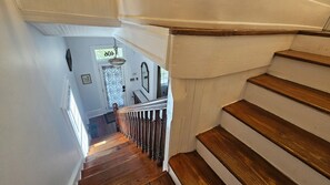 A wooden staircase with a white handrail leading to a landing. - Historic 3-bedroom house in downtown Brooklyn Arts district (Wilmington)