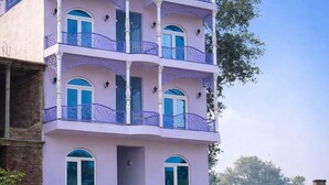 A multi-story building with balconies and arched windows. - Ray Of Maya Retreat and Resorts (Agra)