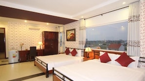 A hotel room with two beds, a desk, a chair, and a view of the city. - Omega Hotel (Da Nang Municipality)