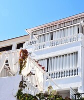 Un edificio blanco con balcones y cielo despejado.