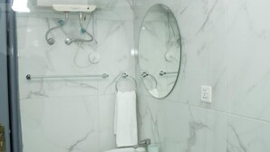 Een badkamer met een wit wastafel, een spiegel, een handdoekhouder en een douchepaneel.