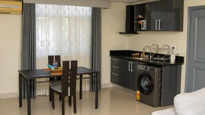 Un espacio habitable funcional con comedor, cocina y lavadora.