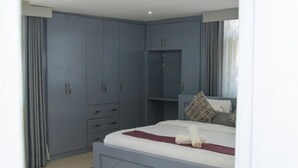 Een slaapkamer met een bed, een kledingkast en een ingebouwde bank.