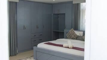 A bedroom with a bed, a wardrobe, and a built-in bench.