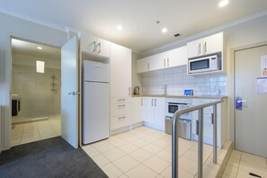 A modern kitchen with white cabinets, a microwave, and a stainless steel refrigerator. - U Residence Wellington, BW Signature Collection (Wellington)