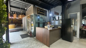 A reception desk with a sign for 'HARTIKA HOTEL' and a 'LIFT KUSUS' sign above it.