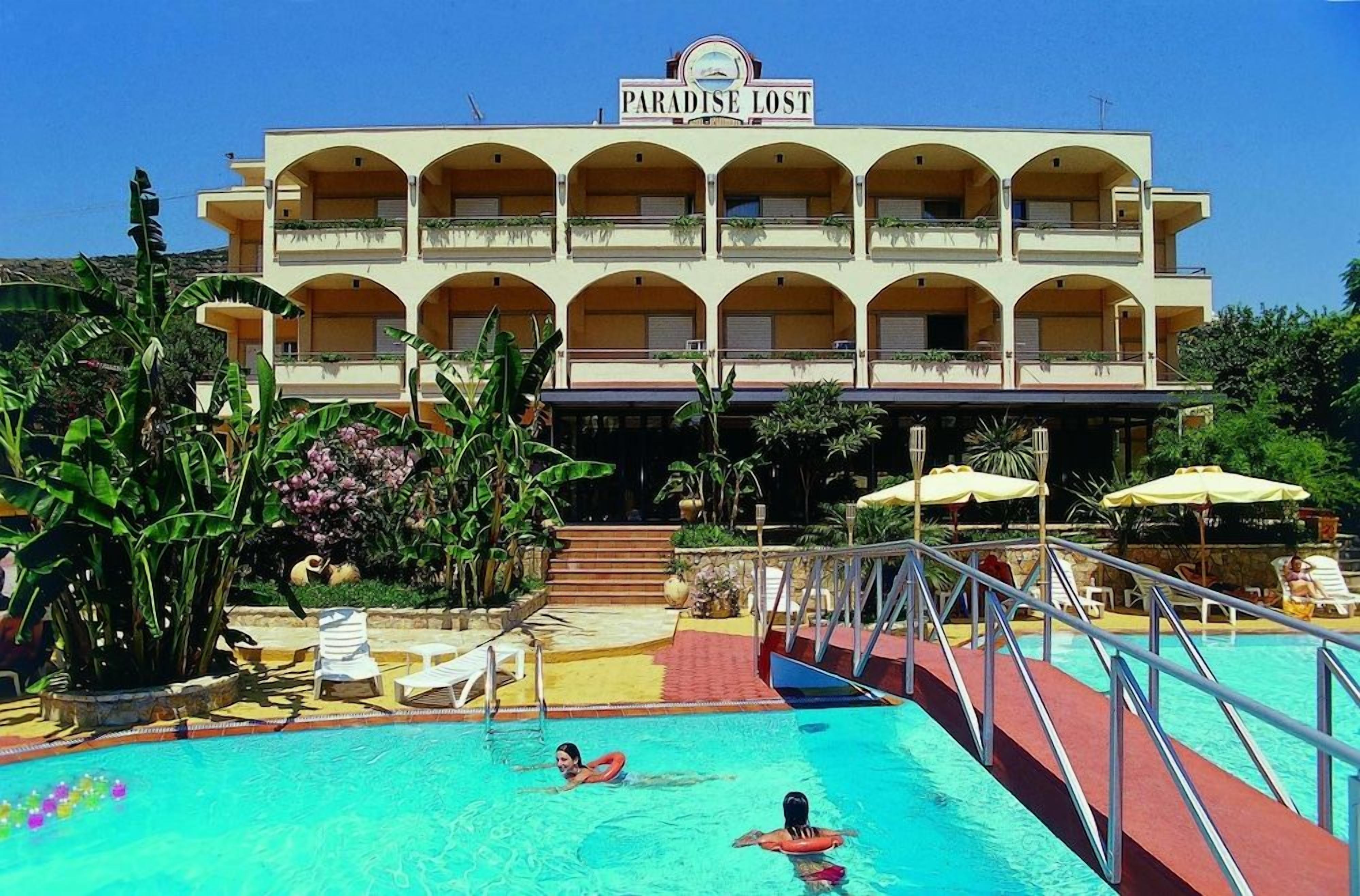 A hotel named 'Paradise Lost' with a swimming pool, lounge chairs, and a covered area with umbrellas.