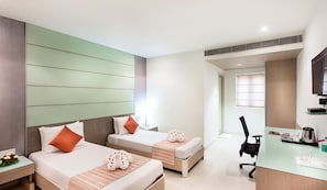 A hotel room with two beds, a desk, and a chair. - The Lotus Service Apartments (Chennai)