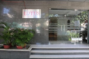 A building entrance with a sign reading 'LOTUS service apartment' and a staircase leading up to the entrance. - The Lotus Service Apartments (Chennai)