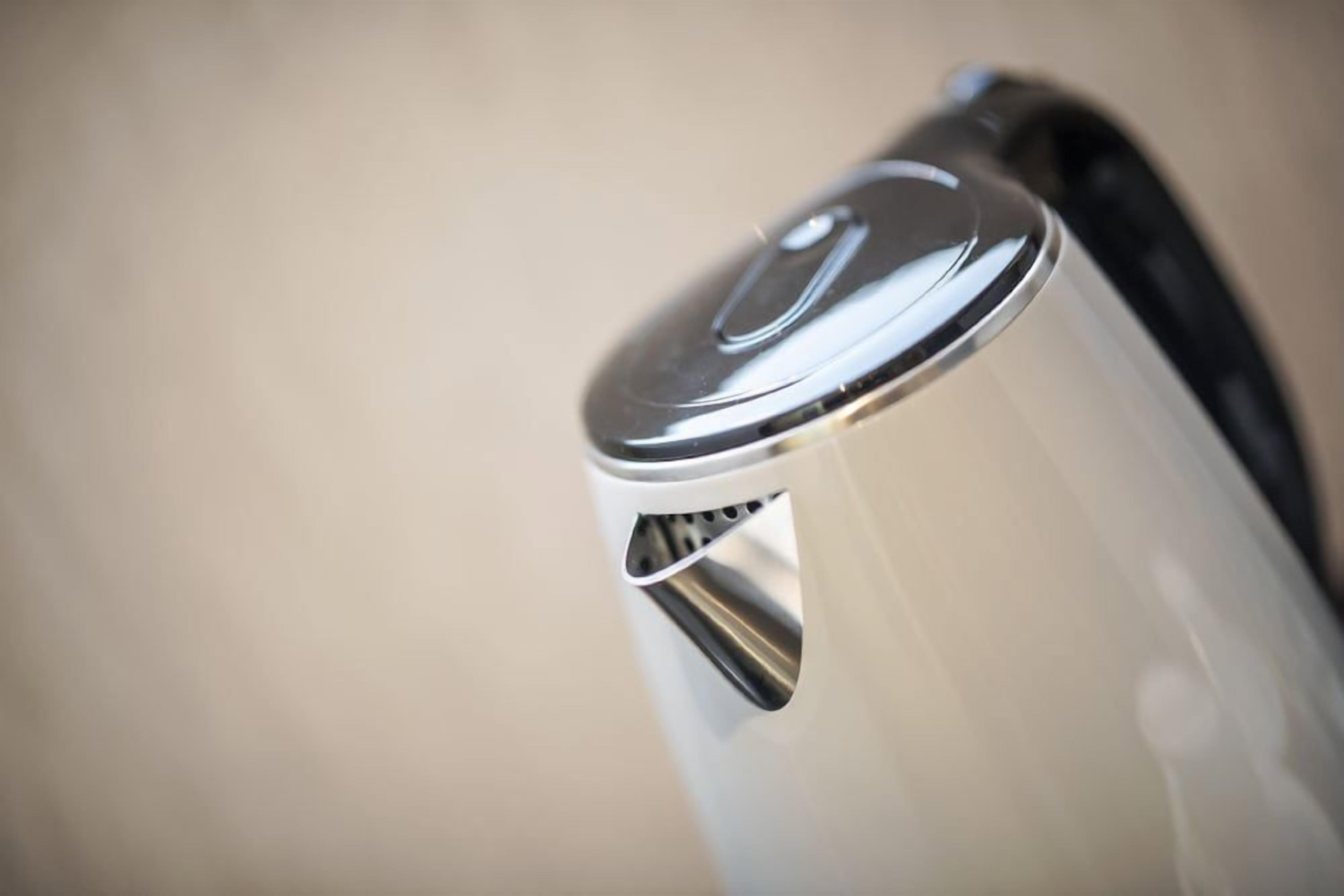 A close-up of a metallic kettle with a lid.