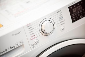 Eine Waschmaschine mit Bedienfeld, digitalem Display und einer Kennzeichnung für 9 Kilogramm Fassungsvermögen.