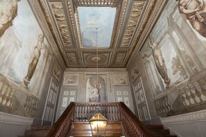 A grand staircase with ornate railings and a chandelier, leading to a high ceiling with detailed frescoes and a skylight. - Lostwithiel Manor - Nine Bedroom Villa, Sleeps 18 (Boconnoc)
