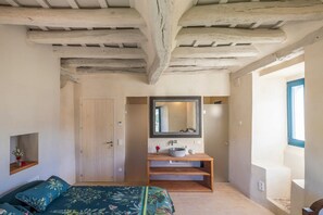Une chambre à coucher avec un lit, une coiffeuse en bois, un miroir et une fenêtre.