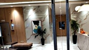 A modern lobby with a marble floor, a reception desk, a seating area, and a large painting on the wall. - Cozy studio in lovely Quezon City with refreshing AC (Quezon City)