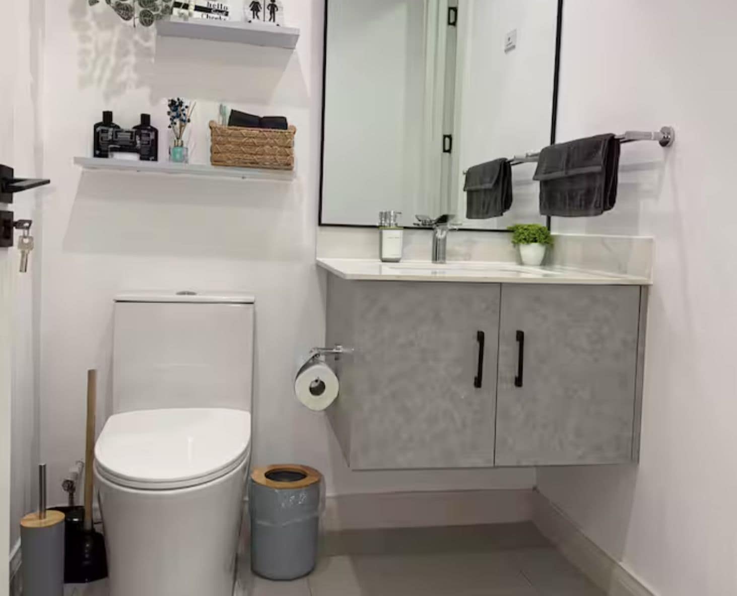 Un baño moderno con inodoro, lavamanos y un mueble.