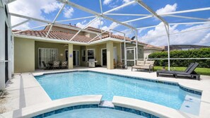 A swimming pool with a covered patio area, outdoor furniture, and a clear sky. - 5BR Tuscan Hills Villa Pool & Themed Rooms (Davenport)