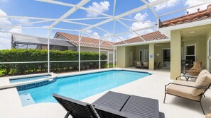 A swimming pool with a glass ceiling, surrounded by greenery, and a patio area with outdoor furniture. - 5BR Tuscan Hills Villa Pool & Themed Rooms (Davenport)