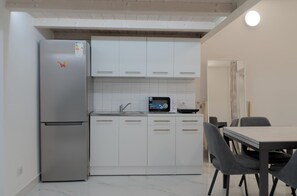 A compact kitchen with a refrigerator, microwave, and cabinets. - La Corte Romana · Il fascino nel centro di Verona (verona)