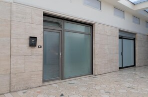 A building facade with large glass doors, a mail slot, and a tiled floor. - La Corte Romana · Il fascino nel centro di Verona (verona)