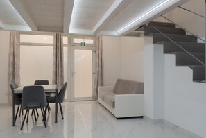 A modern interior with a dining area, a sofa, and a staircase. - La Corte Romana · Il fascino nel centro di Verona (verona)