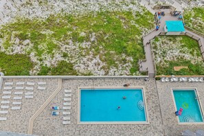 A rooftop pool area with multiple swimming pools, a wooden deck, and lounge chairs. - 🌊 Enjoy Stunning Gulf Views | Fabulous Amenities | SunDestin 1803🌊 (Destin)
