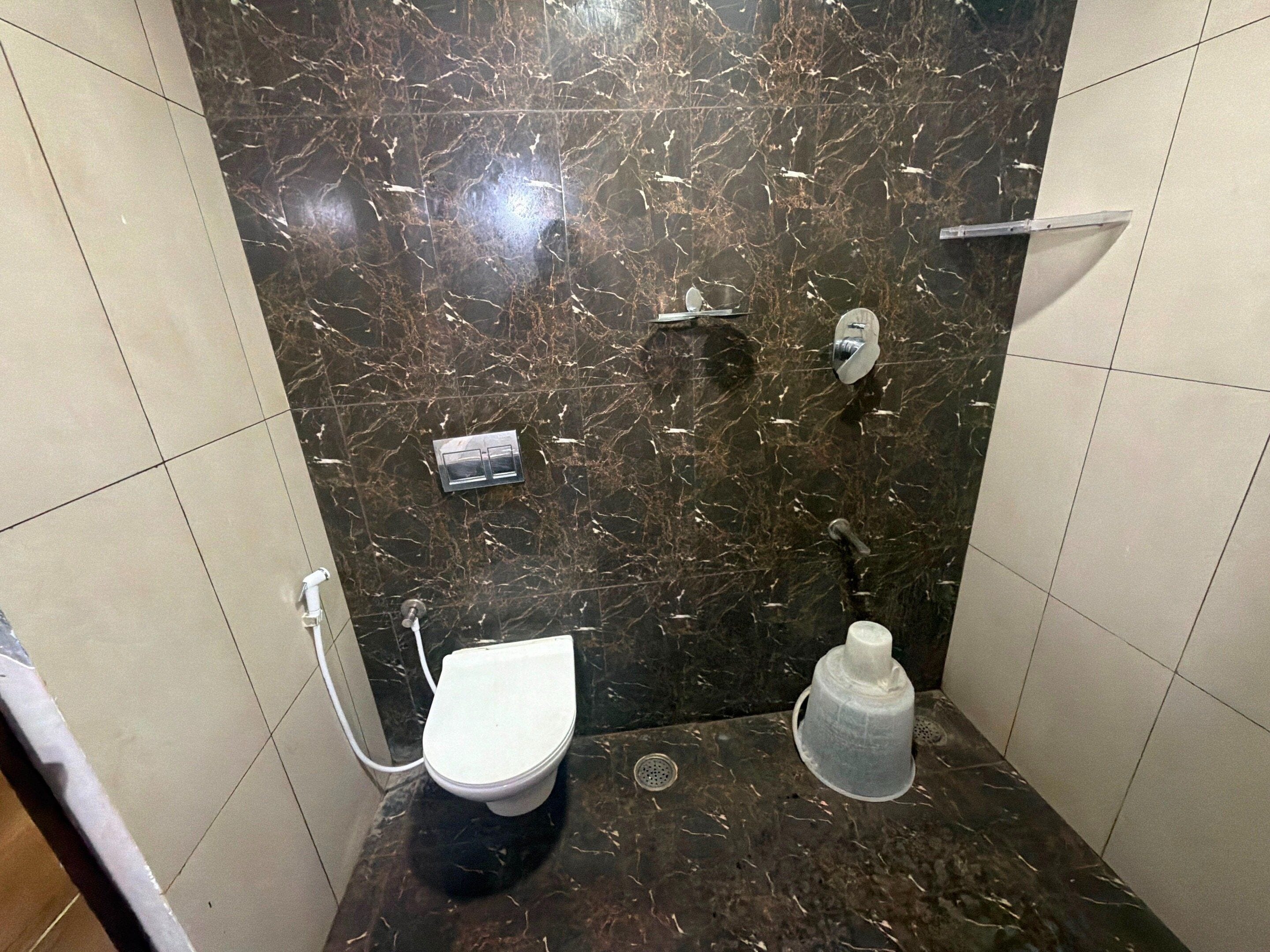 A bathroom with a toilet, a shower, and a sink.
