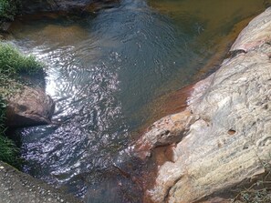 Ein naturbelassener Bach fließt über Felsen.