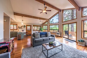A spacious living area with a gray sofa, a coffee table, and a ceiling fan. - Stylish Zen Mountain Villa: Hot Tub, Games & Views (Flagstaff)