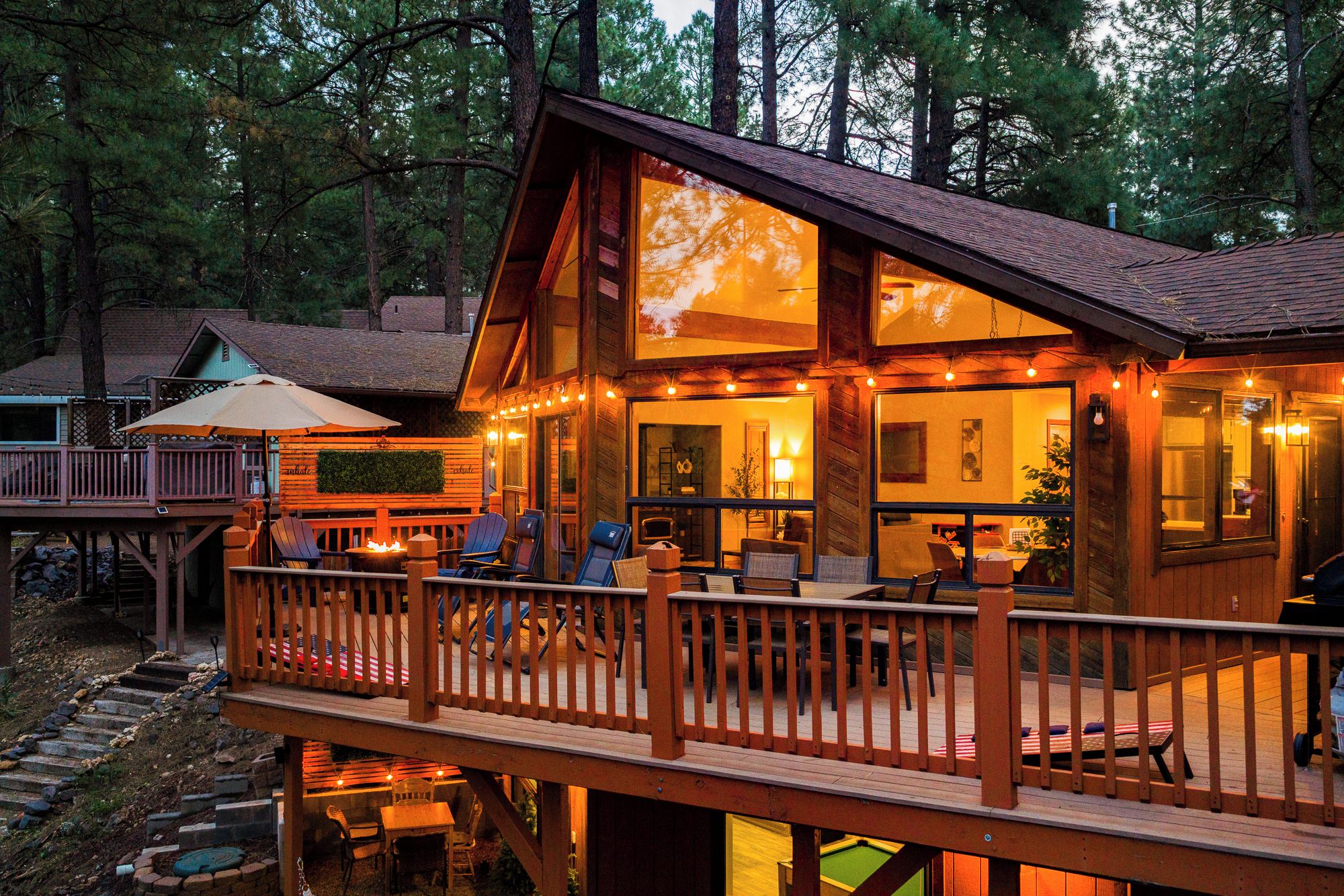 Une cabane en bois dotée d’une terrasse, d’un espace salon extérieur et d’une piscine.