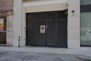 Ein geschlossener Metallrollladen mit einem 'passo carrabile'-Schild, das einen Behindertenparkplatz kennzeichnet.
