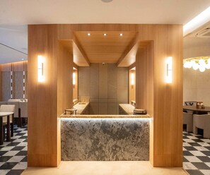 A modern interior with a central reception desk, wooden paneling, and a checkered floor. - Executive Room Checkin Amritsar (Amritsar)